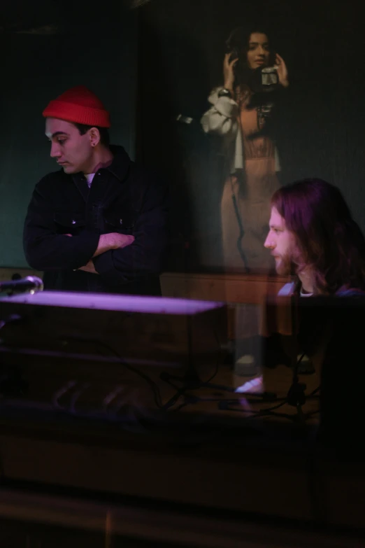 a man sitting at a desk in front of a computer, an album cover, flickr, antipodeans, medium shot of two characters, at a bar, ignant, keyboardist