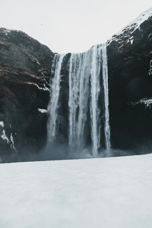 a person standing in front of a waterfall, pexels contest winner, hurufiyya, snow and ice, tears running down, slightly smooth, ground level shot