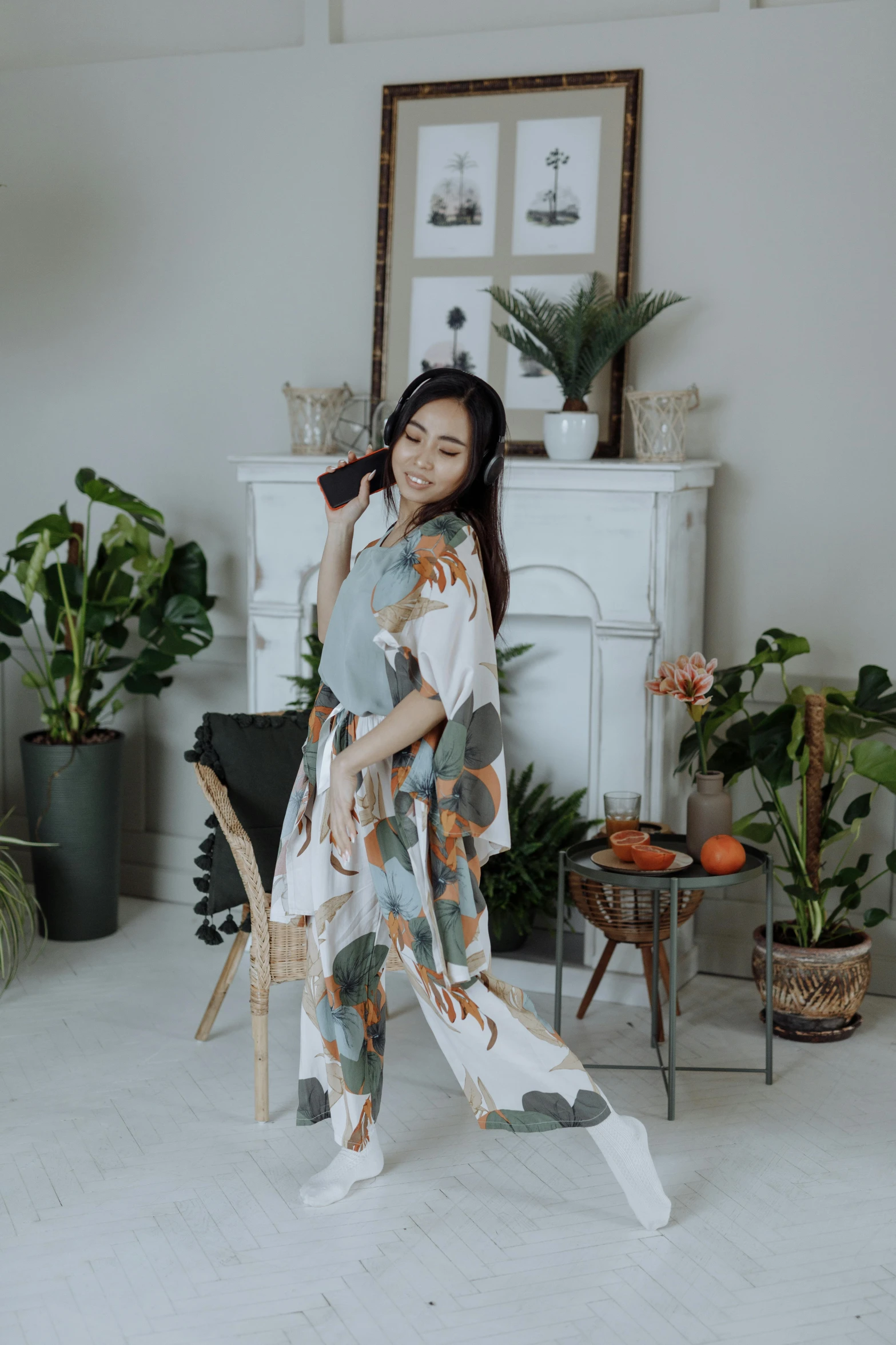 a woman standing in a living room holding an umbrella, inspired by Gao Kegong, instagram, art nouveau, wearing white pajamas, foliage clothing, promo image, low quality photo