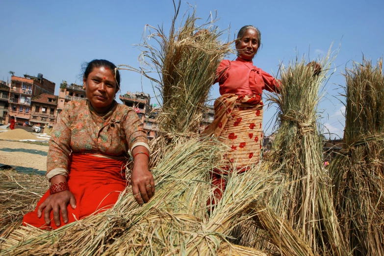 a couple of women standing next to each other, hurufiyya, organic biomass, straw, avatar image, slum