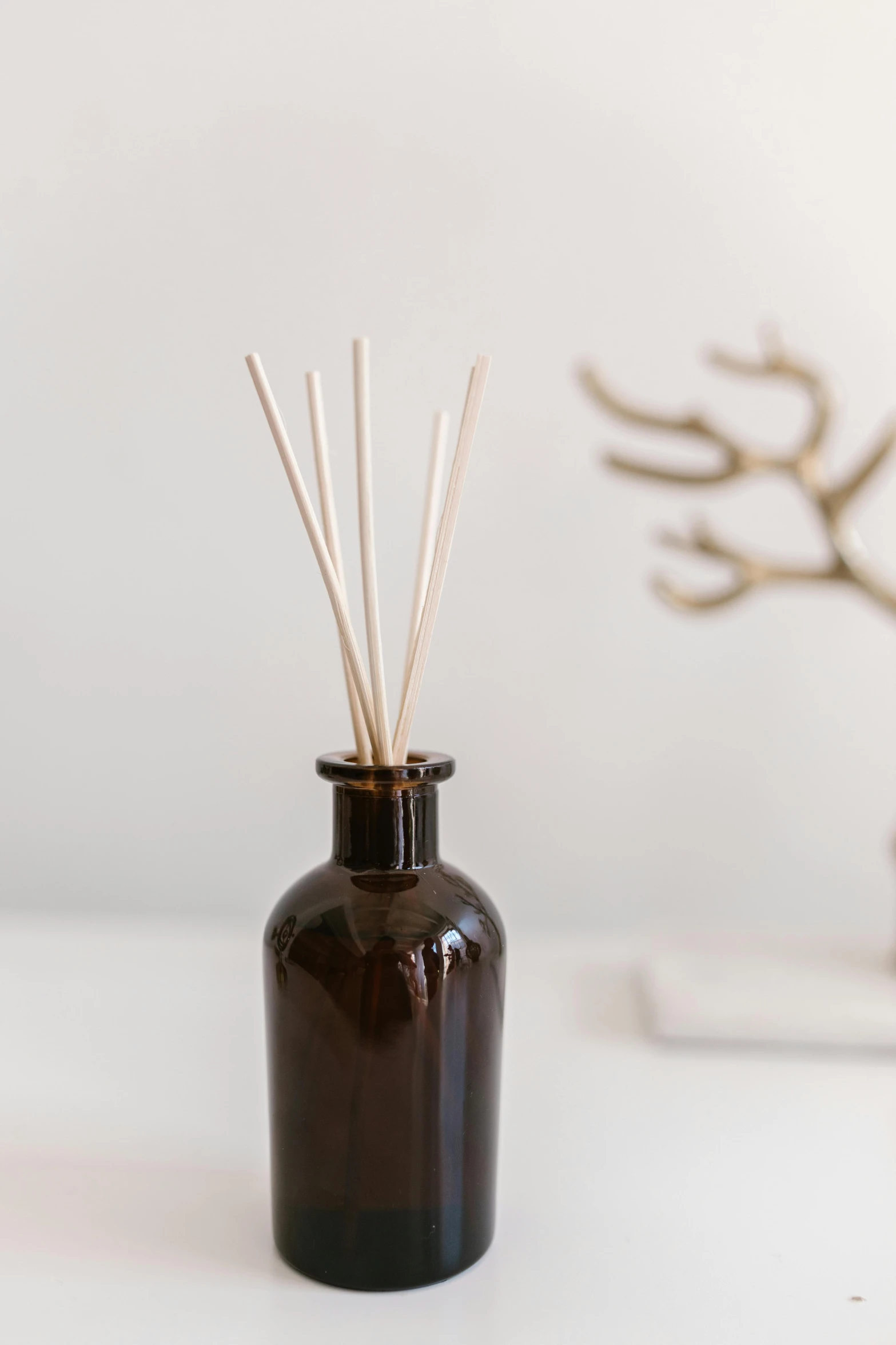 a bottle that has some sticks in it, unsplash, home display, brown, product, smokey