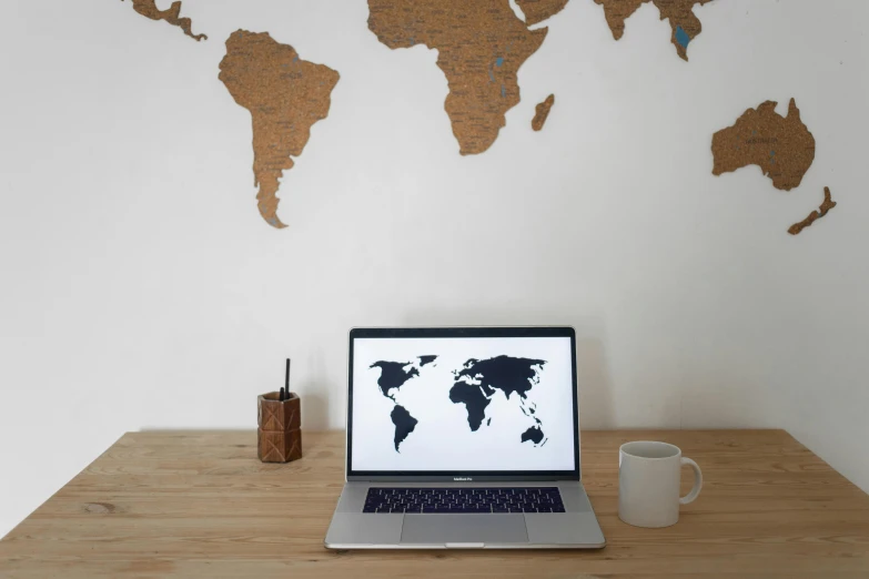 a laptop computer sitting on top of a wooden desk, a computer rendering, pexels, world map, wooden decoration, white bg, brown