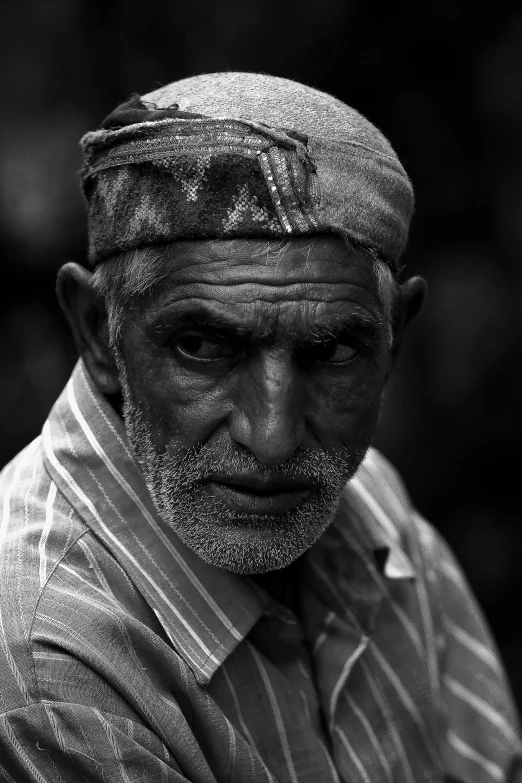 a black and white photo of an old man, by Ahmed Yacoubi, serious focussed look, photo of a man, unhappy, bluish face