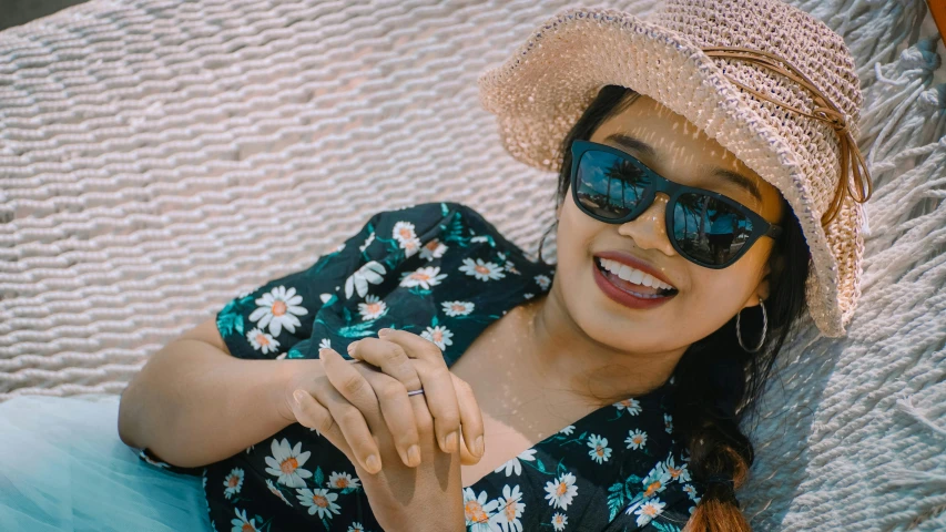 a woman laying in a hammock wearing a hat and sunglasses, pexels contest winner, hurufiyya, mutahar laughing, assamese aesthetic, youtube thumbnail, hand on her chin