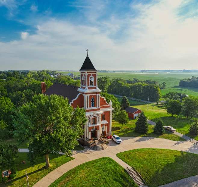 a church sitting on top of a lush green field, a picture, by Robert Storm Petersen, unsplash contest winner, northwest school, iowa, town hall, wide high angle view, background image