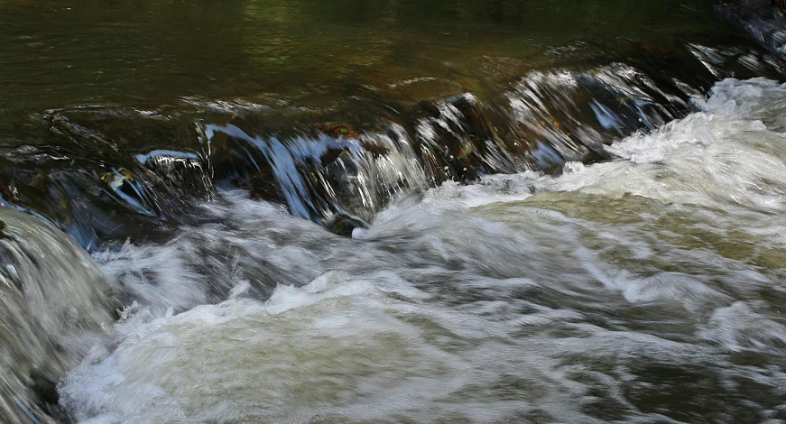 a man riding a surfboard on top of a river, by David Simpson, pexels contest winner, hurufiyya, falling water, abstract photography, babbling brook, small river on the ground