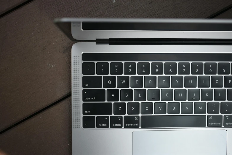 a laptop computer sitting on top of a wooden table, by Carey Morris, pexels, perfect kerning, close-up from above, pbr materials, keys