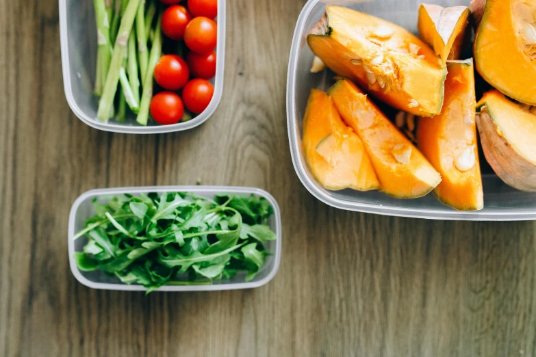 a couple of containers filled with food on top of a wooden table, by Nicolette Macnamara, pexels, plasticien, greens, profile image, fresh, family friendly