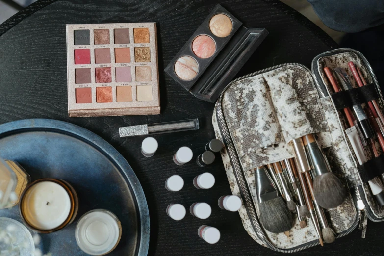 a suitcase full of makeup sitting on top of a table, a still life, unsplash, metal surfaces, sustainable materials, grey, game ready