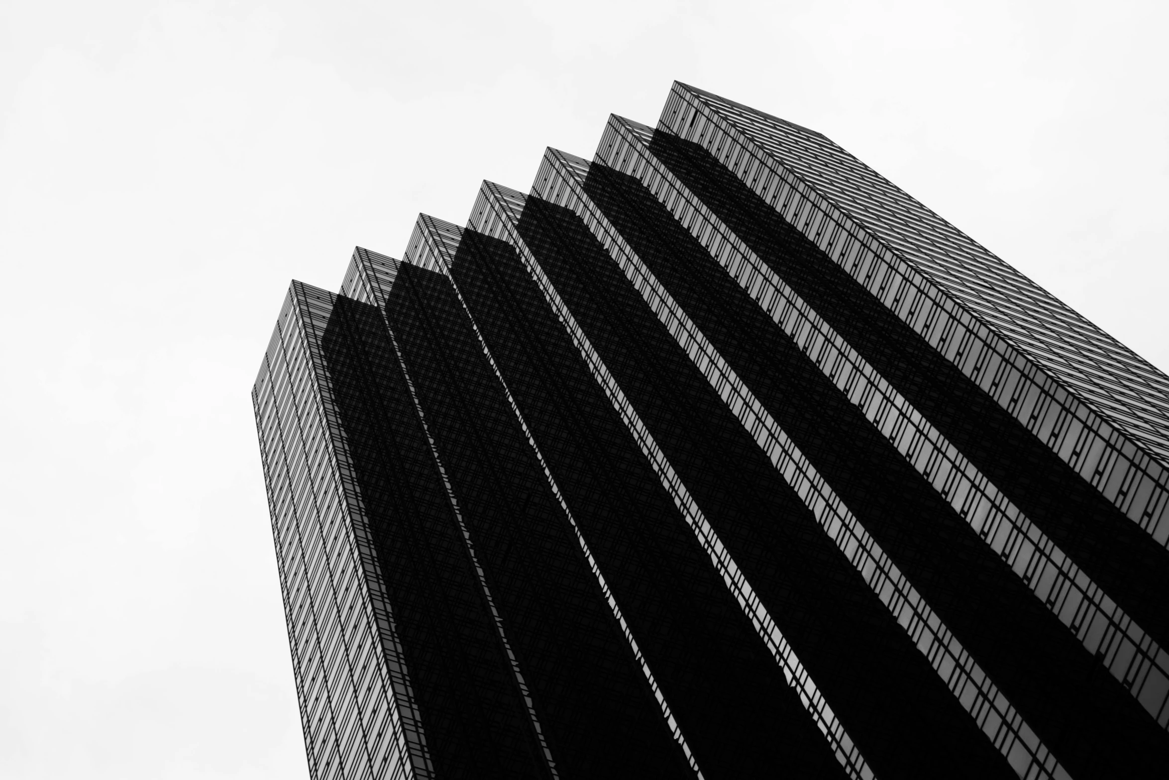 a black and white photo of a tall building, by Andrew Domachowski, pexels contest winner, square lines, black color on white background, gardena architecture, sins inc skyscraper front