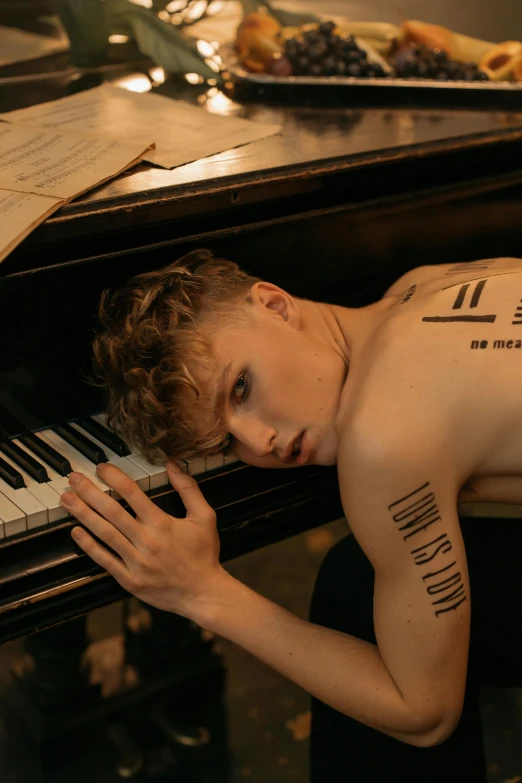 a young man laying on top of a piano, an album cover, by Jessie Alexandra Dick, trending on pexels, non binary model, sweaty skin, caspar david, keys
