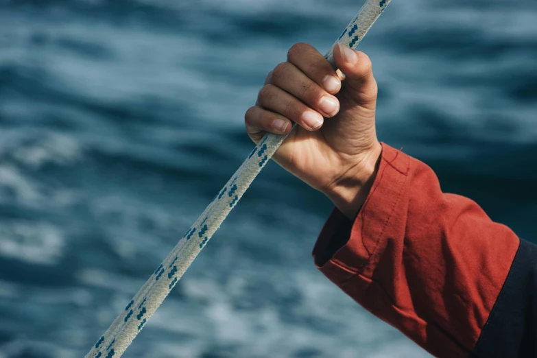 a person holding a rope over a body of water, zoomed in, profile image