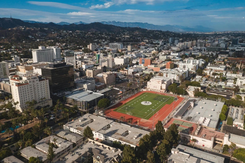 an aerial view of a soccer field in a city, by Marshall Arisman, unsplash, renaissance, the city of santa barbara, downtown in the distance, art deco stadium, private school