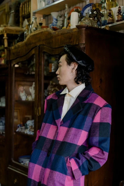 a man standing next to a woman in a room, a portrait, inspired by Maeda Masao, unsplash, de stijl, wearing a purple detailed coat, tartan garment, in historic clothing, official store photo