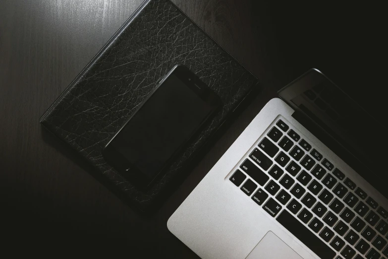 a laptop computer sitting on top of a wooden table, black on black, iphone wallpaper, white and black, square