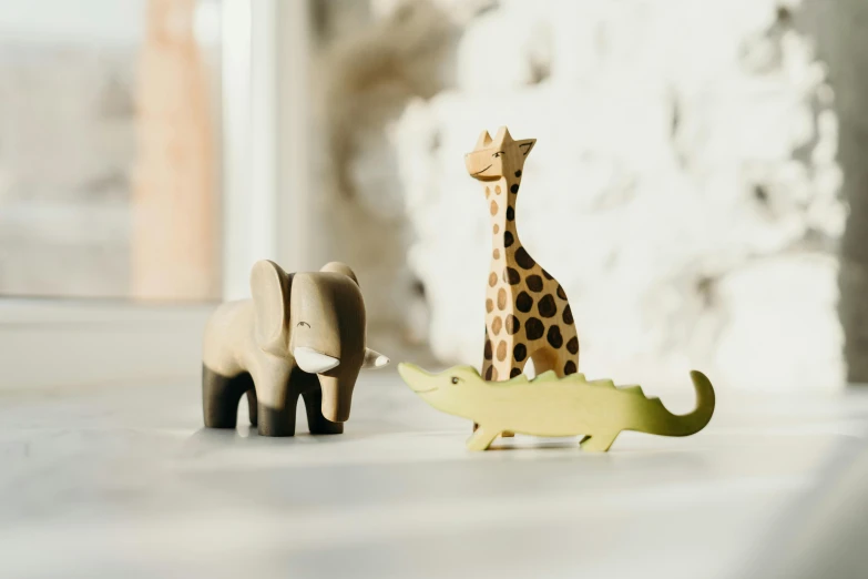 a giraffe and an elephant standing next to each other, inspired by Sarah Lucas, trending on unsplash, figuration libre, wooden decoration, children's toy, three animals, close-up product photo