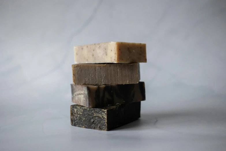 a stack of soap bars sitting on top of each other, by Emma Andijewska, chocolate. rugged, black, small, thumbnail