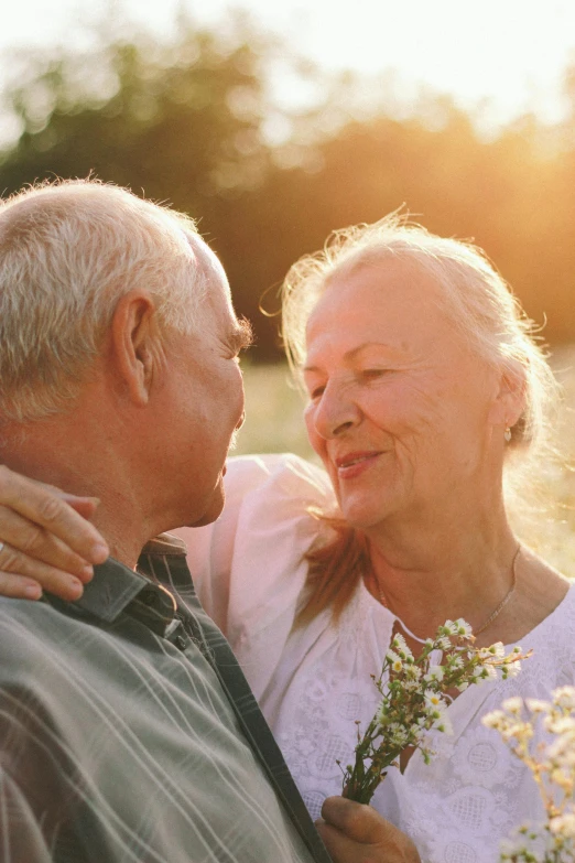 a man and woman standing next to each other in a field, pexels contest winner, romanticism, older woman, sunny lighting, hearts, profile image