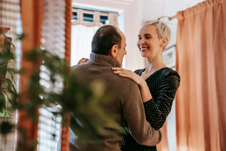 a woman standing next to a man in a living room, by Emma Andijewska, pexels contest winner, romanticism, girl with short white hair, giggling, romantic lead, rectangle