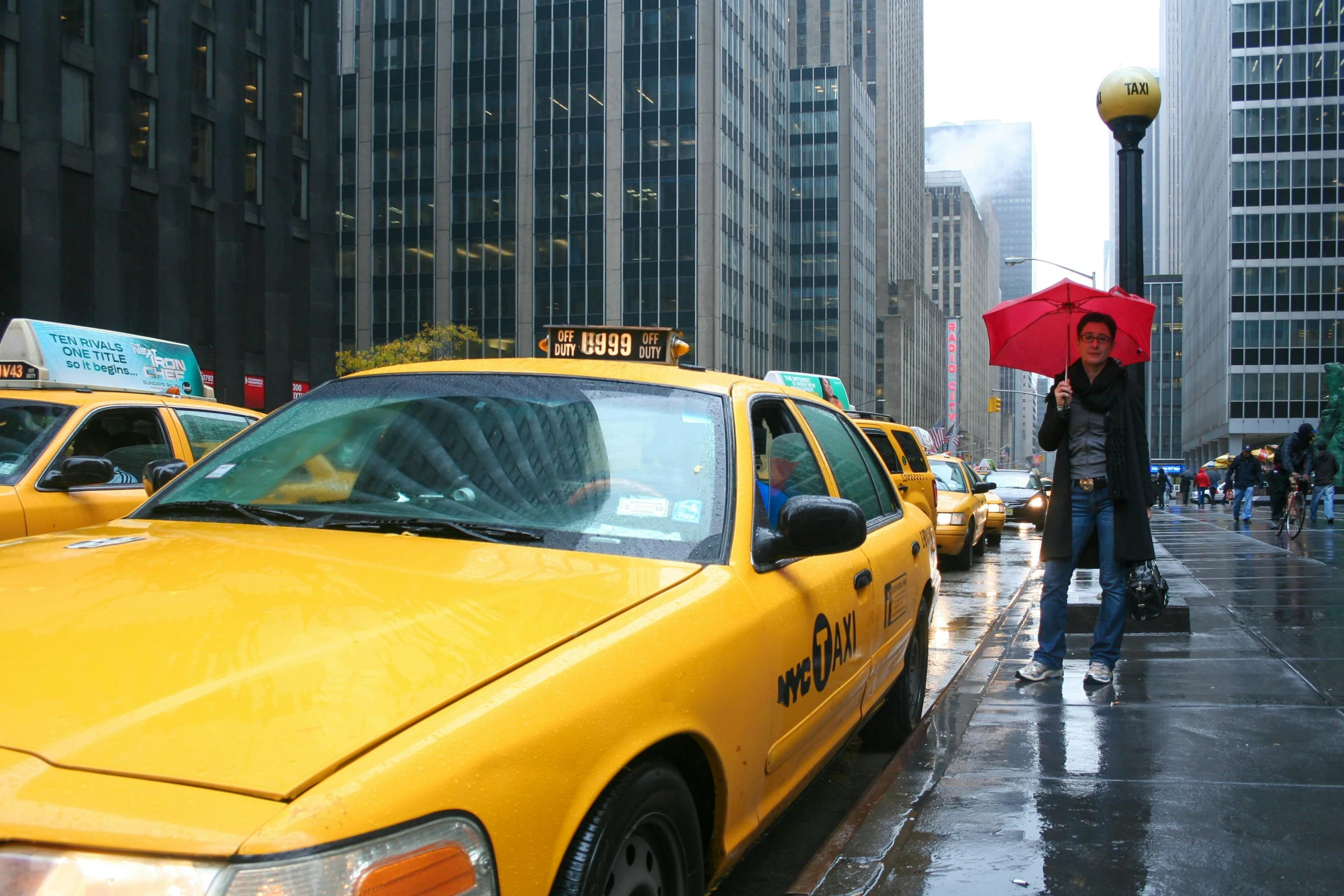 a taxi cab on a city street in the rain, a picture, photograph