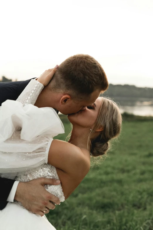 a bride and groom kissing in a field, unsplash, lake view, close body shot, boys, - photorealistic