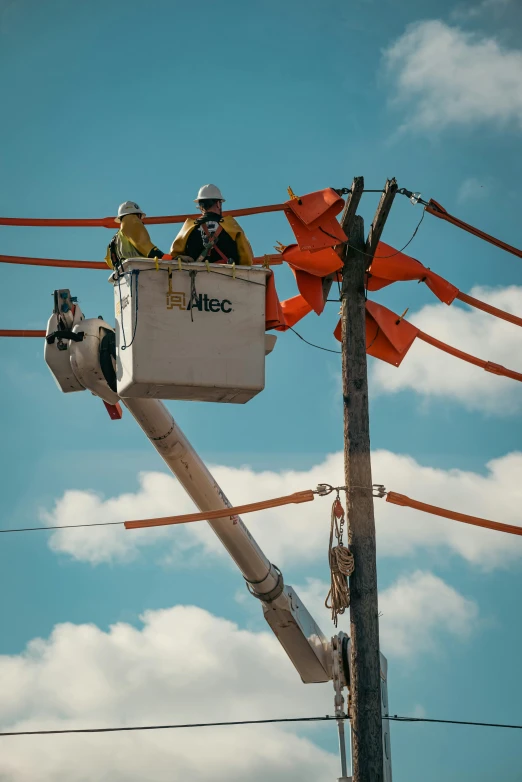 a man on a cherry picker working on a power line, by Greg Rutkowski, pexels contest winner, orange electricity, masks on wires, promo image, color picture