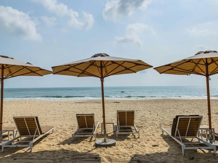 beach chairs and umbrellas on a sandy beach, pexels contest winner, sri lankan landscape, brown, 120 degree view, icon