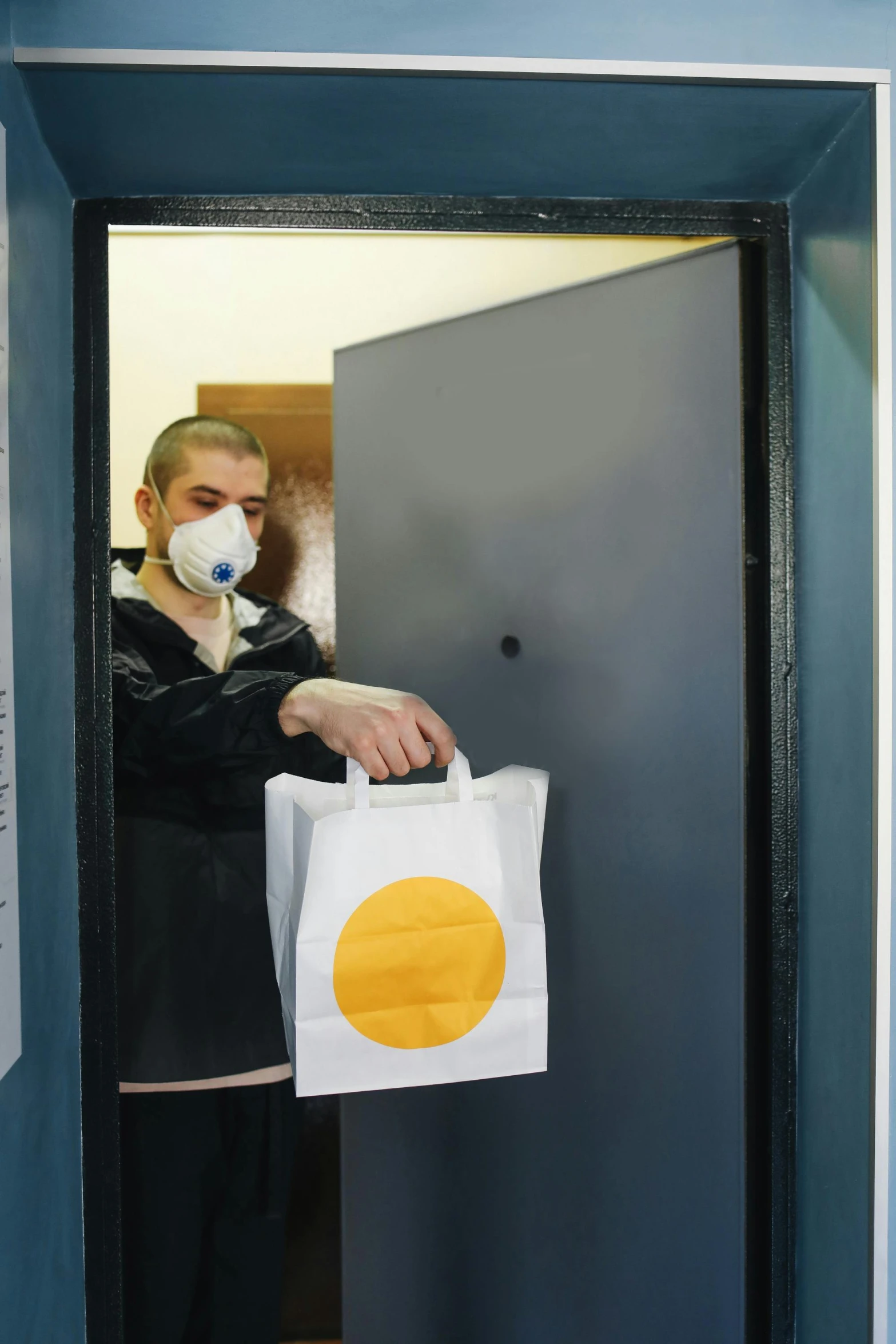 a man holding a bag in front of a door, reddit, private press, with a bright yellow aureola, medical mask, at checkout, anna nikonova