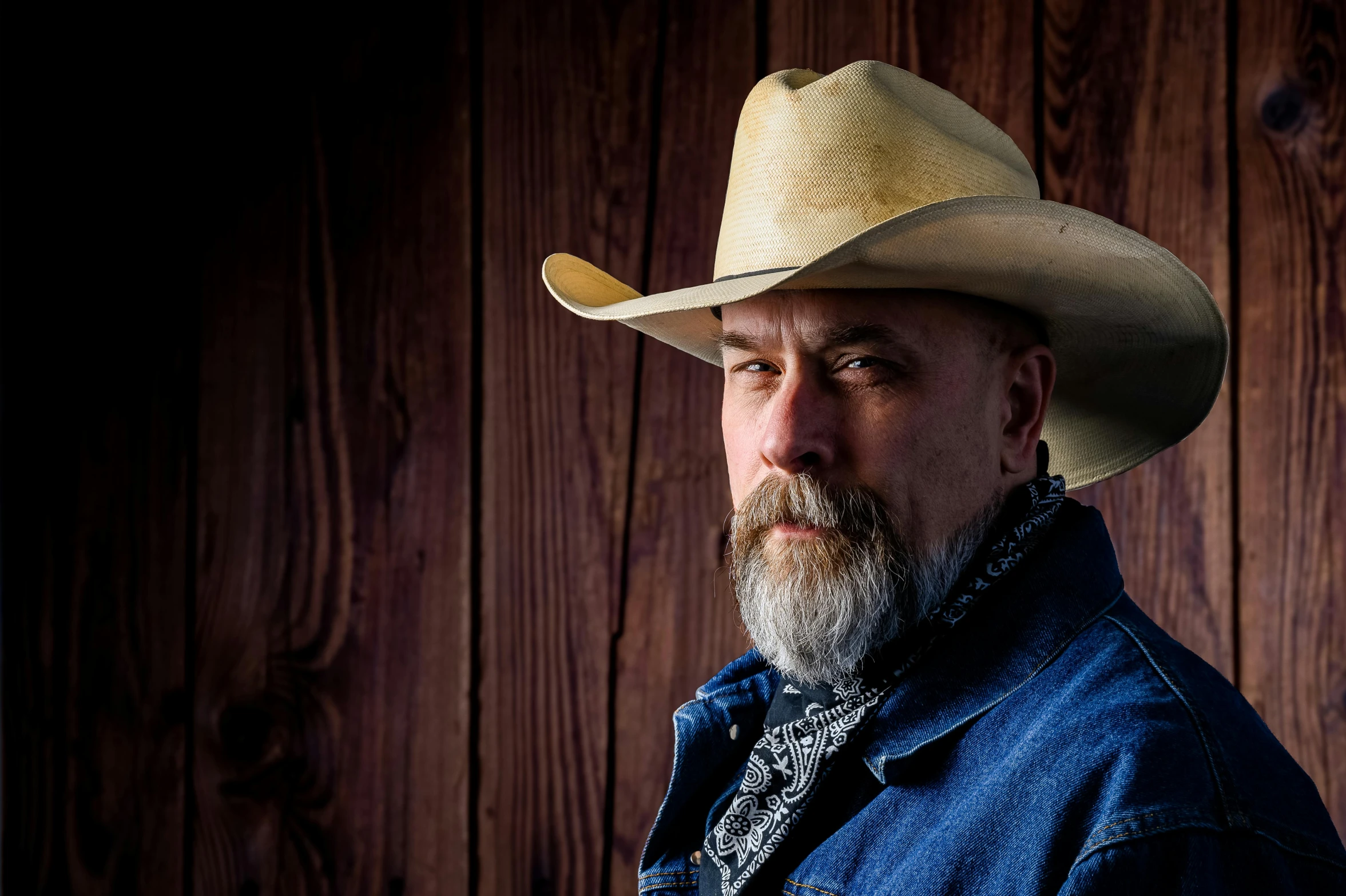 a man with a beard wearing a cowboy hat, a portrait, unsplash, photorealism, short white beard, square, half blue, robb cobb