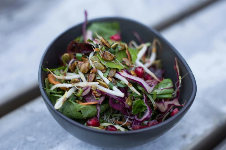 a close up of a bowl of food on a table, by Alice Mason, unsplash, salad, “ iron bark, festive, exterior shot