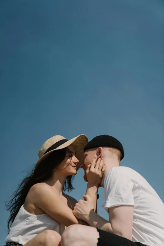 a man and a woman sitting next to each other, a picture, by Attila Meszlenyi, pexels contest winner, wearing a chocker and cute hat, clear blue sky, kissing each other, 15081959 21121991 01012000 4k