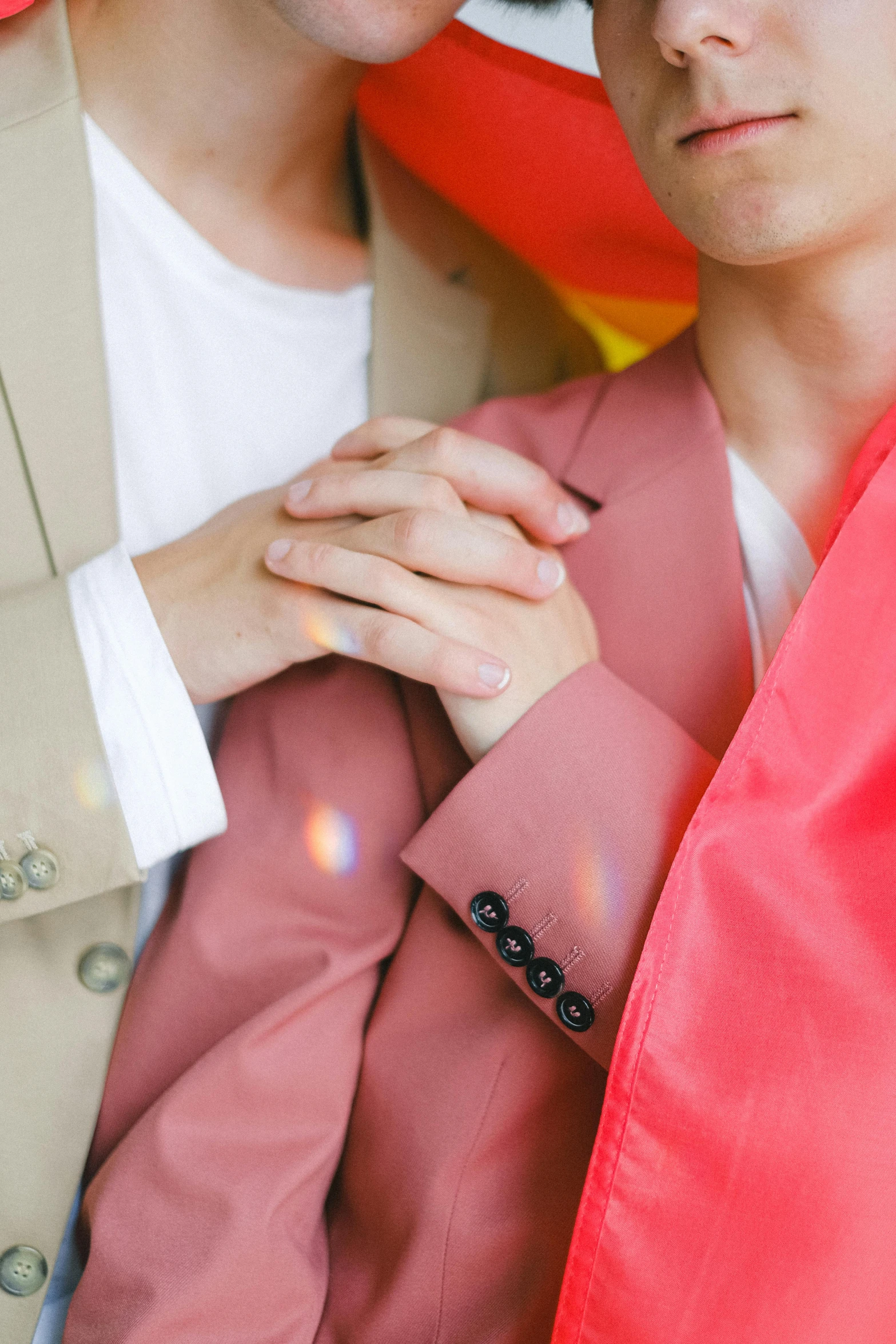 a couple of men standing next to each other, an album cover, by Julia Pishtar, trending on unsplash, hands crossed, wearing a colorful men's suit, lesbian embrace, high angle close up shot