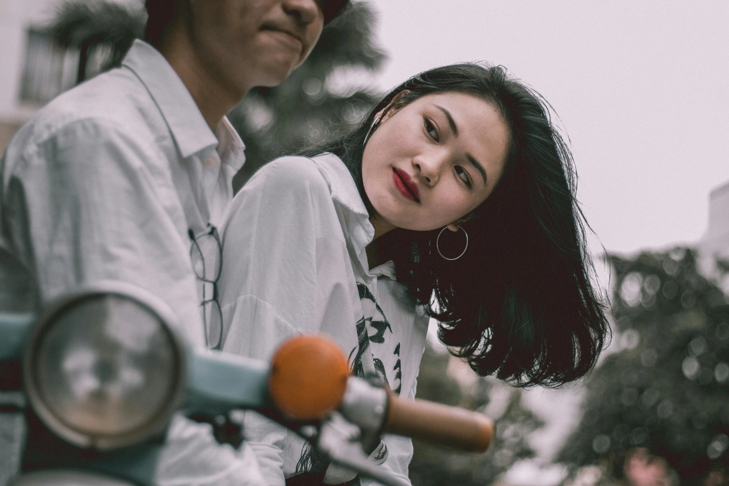 a man and a woman sitting on a scooter, trending on pexels, realism, detailed face of a asian girl, 15081959 21121991 01012000 4k, looking her shoulder, colour photo