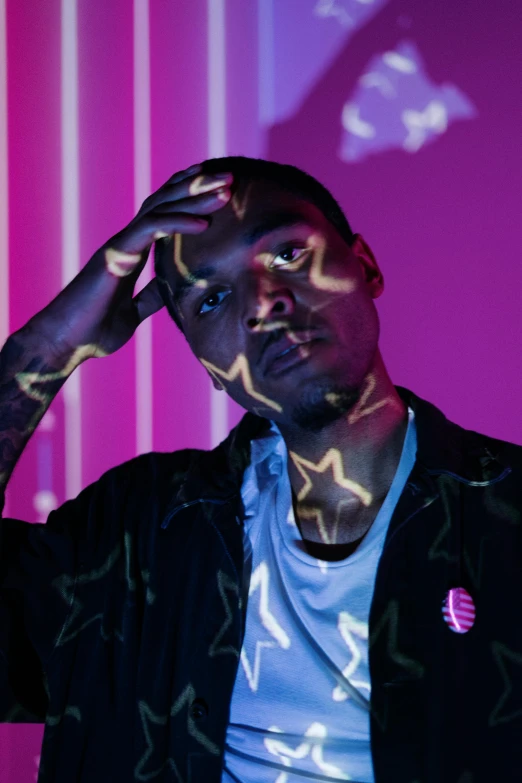 a man standing in front of a pink wall, an album cover, by Cosmo Alexander, glowing with colored light, playboi carti portrait, profile image, j. h. williams iii