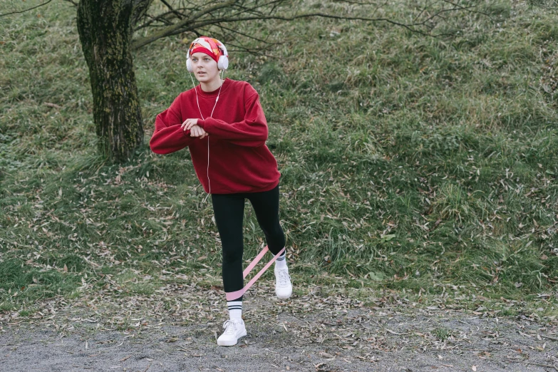 a woman in a santa hat is running with a pair of skis, an album cover, by Emma Andijewska, pexels, happening, red sweatband, yung lean, working out in the field, wearing a pink hoodie