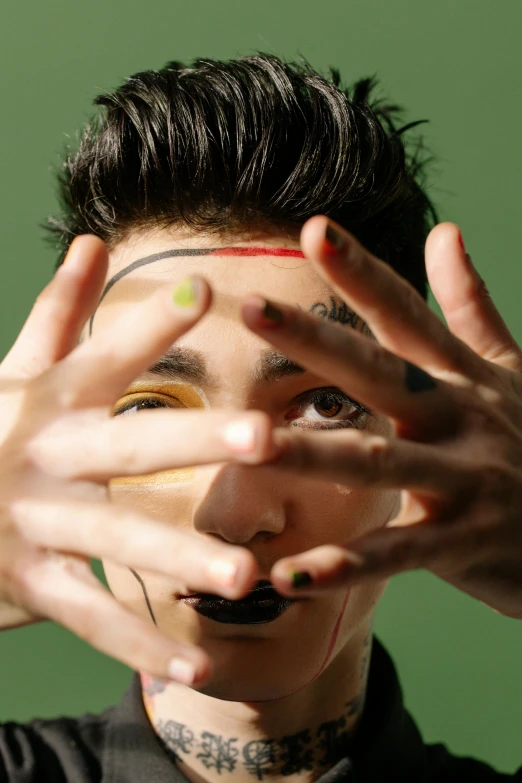 a man covering his eyes with his hands, an album cover, inspired by Taro Yamamoto, trending on pexels, an epic non - binary model, green face, cai xukun, male jester