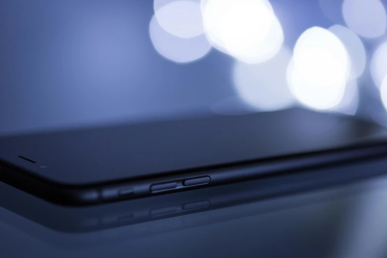 a close up of a cell phone on a table, unsplash, digital art, bokeh volumetric lighting, side profile shot, 15081959 21121991 01012000 4k, took on ipad