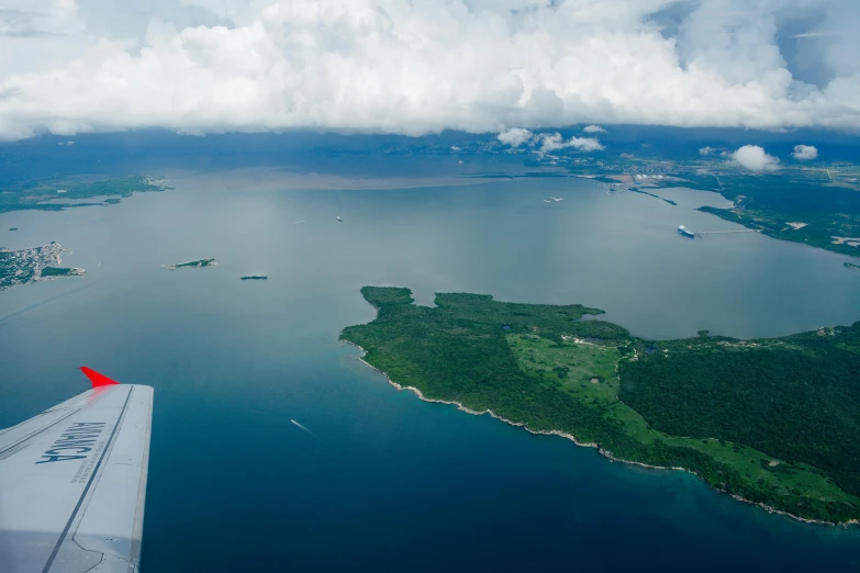 an airplane flying over a large body of water, an island, wide views, views to the ocean, thumbnail