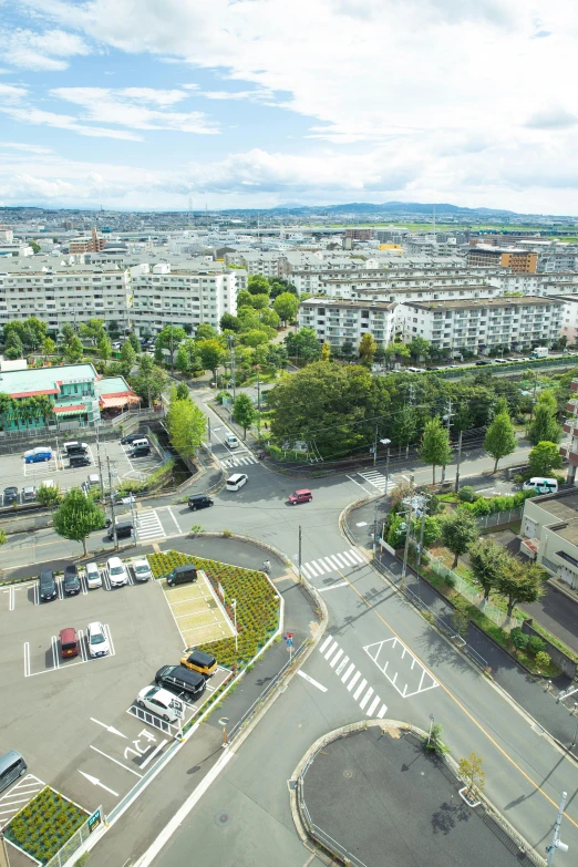 a view of a city from the top of a building, shin hanga, parking lot, grass field surrounding the city, vehicle, streetscapes