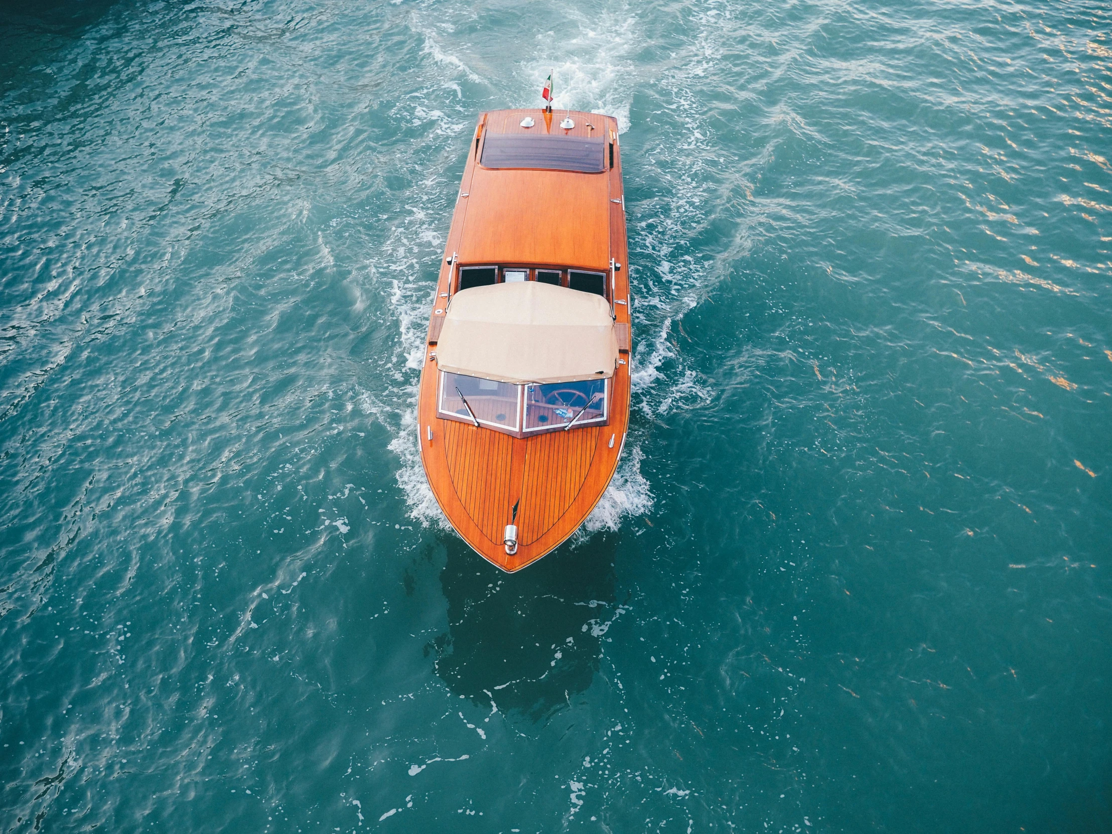 a boat traveling through a body of water, top down, in style of joel meyerowitz, luxurious environment, view from the sky