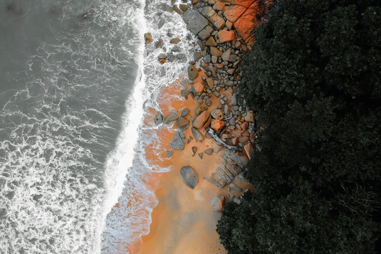 a large body of water next to a beach, inspired by Andreas Gursky, pexels contest winner, environmental art, orange grey white, sandstone, air shot, oil spill