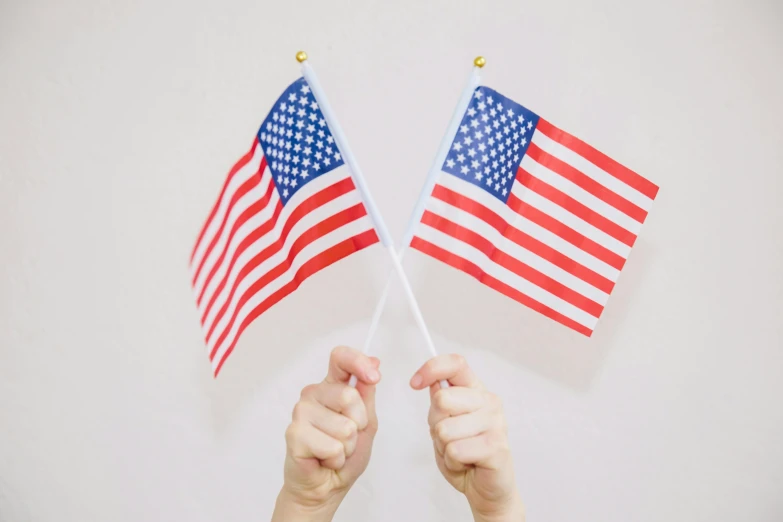 two hands holding american flags against a white background, by Emma Andijewska, pexels, 🚿🗝📝