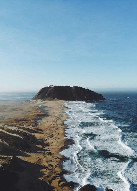 a large body of water next to a sandy beach, by Jacob Burck, unsplash contest winner, land art, hollister ranch, ocean cliff view, an island made of caviar, “ aerial view of a mountain