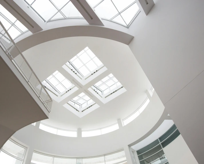 a couple of people that are standing in a building, inspired by Richard Wilson, unsplash, light and space, skylights, white, rounded roof, canopies