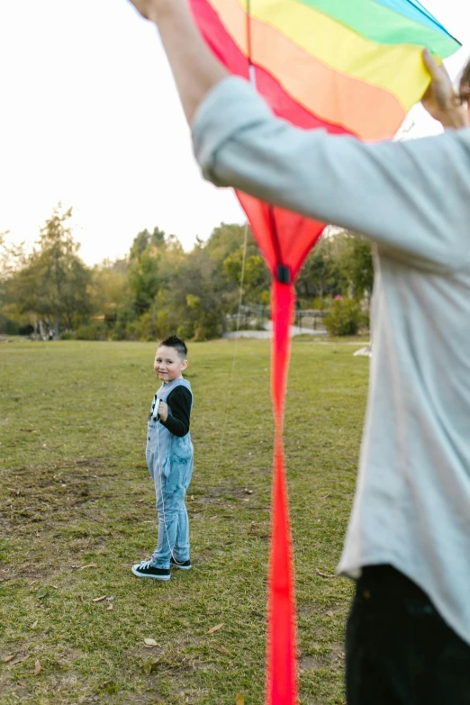 a woman and a child playing with a kite, black shirt with red suspenders, shot with premium dslr camera, carson ellis, panoramic shot