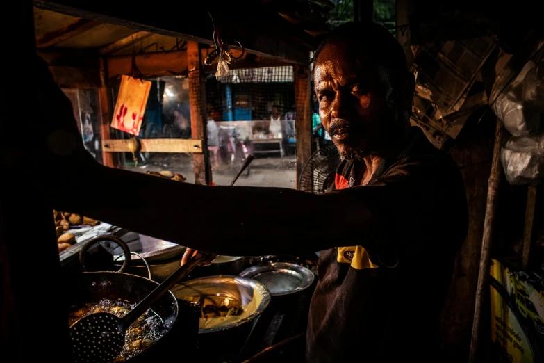 a woman standing in front of a table filled with food, a portrait, pexels contest winner, sun behind him, sri lanka, as chefs inside cthulhu, dramatic action photography