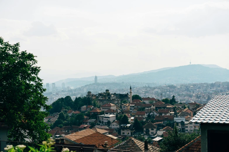 a view of a city from the top of a hill, by Emma Andijewska, pexels contest winner, renaissance, bosnian, slight haze, 1990's photo, slide show