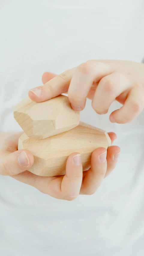 a person holding a wooden block in their hands, a marble sculpture, inspired by Okada Hanko, unsplash, close-up product photo, faceted, 15081959 21121991 01012000 4k