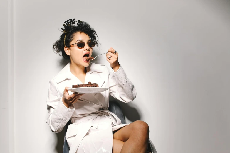 a woman sitting in a chair eating a piece of cake, trending on pexels, renaissance, wearing lab coat and glasses, platon, a young asian woman, hungry