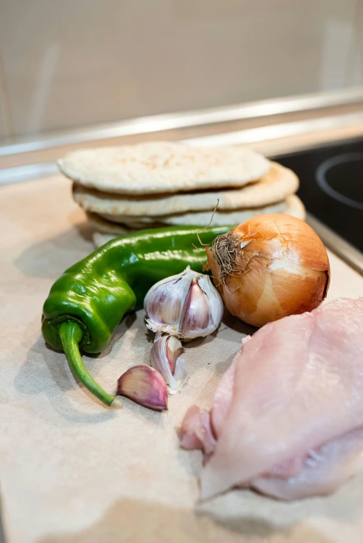 a wooden cutting board topped with meat and vegetables, chicken, taken from the high street, in the kitchen, uncropped